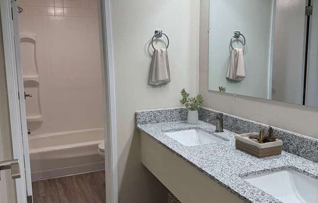 A bathroom with a double sink vanity and a walk-in shower.