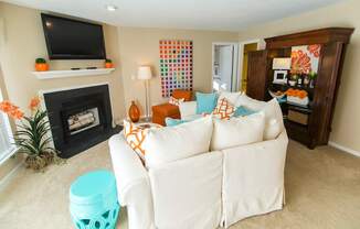 A living room with a white couch and a fireplace.