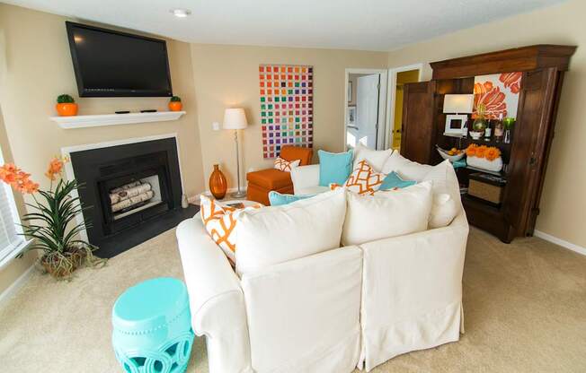 A living room with a white couch and a fireplace.