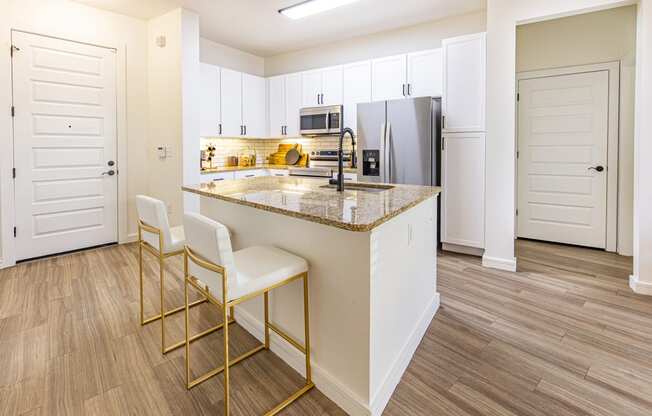 a kitchen with white cabinets and a granite counter top