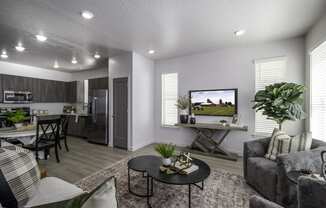 the living room and kitchen of a model home with a couch and a table