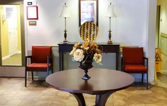 A table with a vase of flowers on it in the middle of a room.