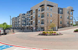 A large apartment complex with a round walkway in front.