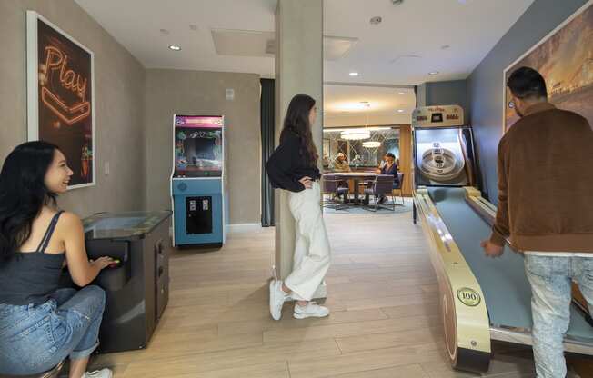 a man and a woman are standing in a room next to a bowling alley