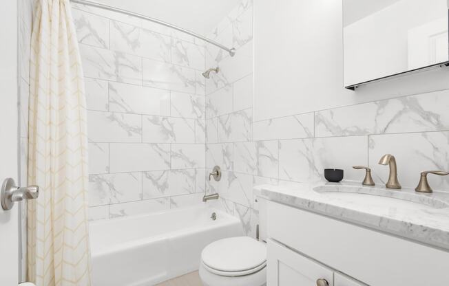 a white bathroom with a shower and a sink and a toilet