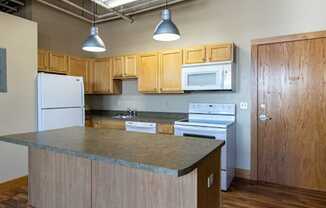 A kitchen with wooden cabinets and a granite countertop.