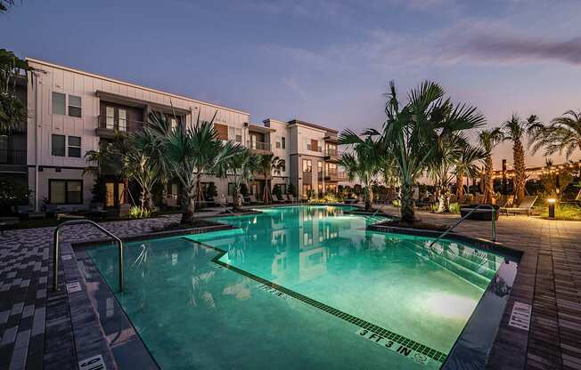 a large swimming pool with apartment buildings in the background