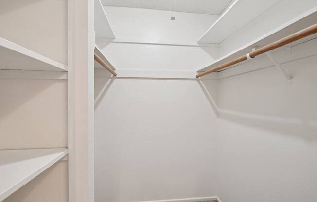 A white closet with shelves and a hanging rod.