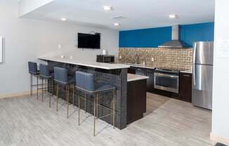 A modern kitchen with a bar area and stainless steel appliances.