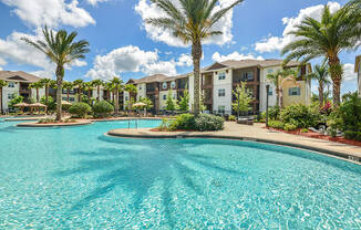 a swimming pool with palm trees in front of an apartment complex  at Cabana Club - Galleria Club, Florida