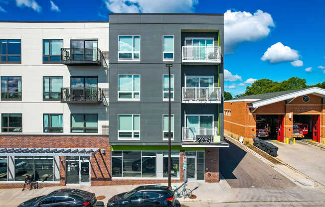 A modern apartment building with a parking lot in front.