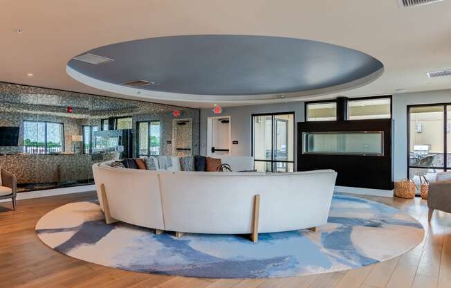 a living room with a large white couch and a blue rug  at Century West Pryor, Lee's Summit, MO