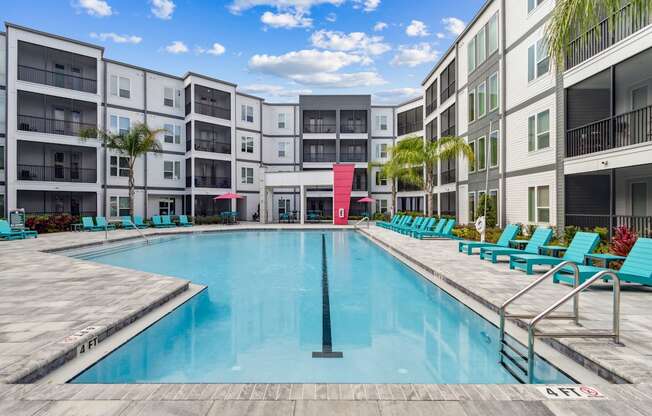 A large swimming pool in front of apartment buildings.