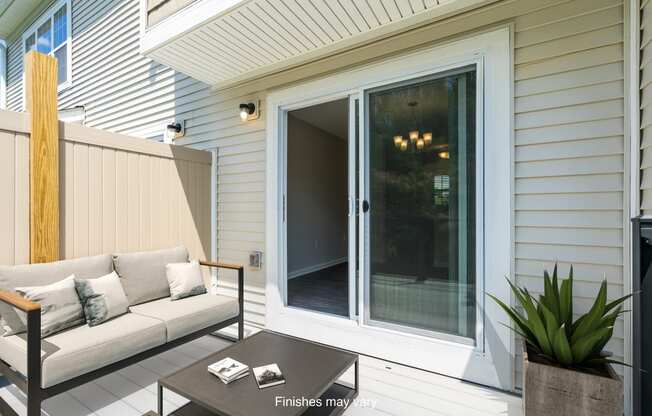 a patio with a couch and a sliding glass door