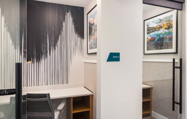 a conference room with a desk and a wall with paintings on it