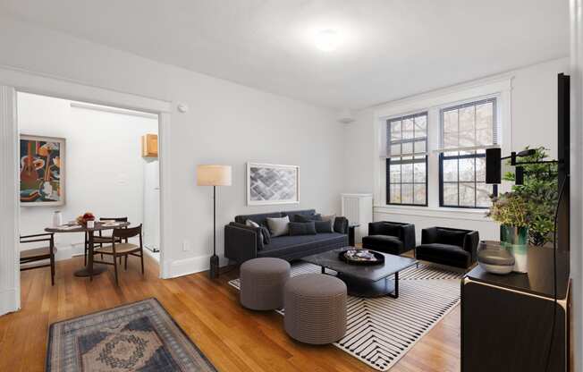 a living room with two couches and a rug and a dining room table