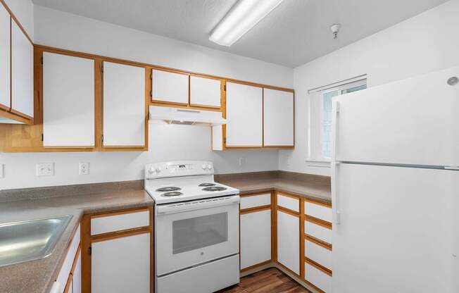 a kitchen with white appliances and wooden cabinets