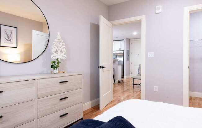 A bedroom with a bed, dresser, and mirror.
