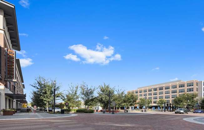 a city street with a building and a blue sky