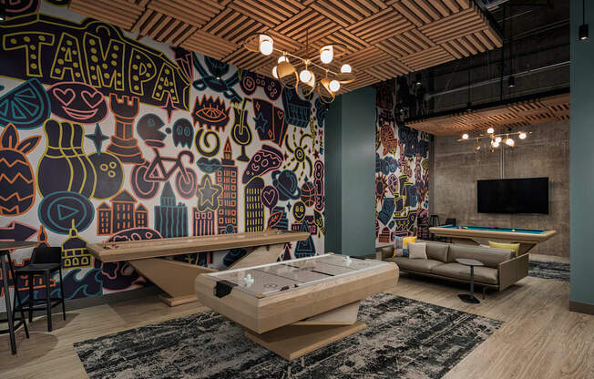 A room with a Tampa mural on the wall and a pool table.