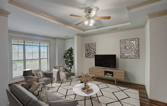 a living room with a ceiling fan and a television