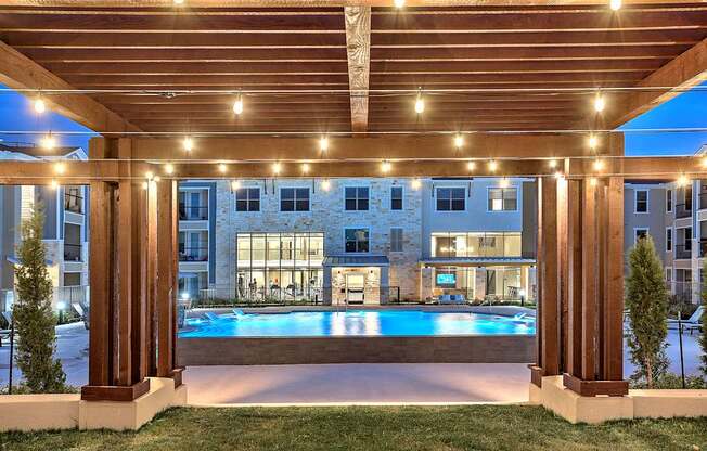 Pool by a wooden pergola with lights at Edge and Stone, San Antonio, 78260
