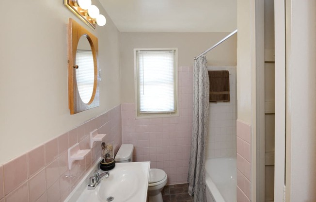 a bathroom with pink tiles and a white sink