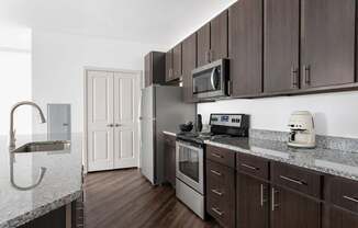 A kitchen with brown cabinets and a white counter.