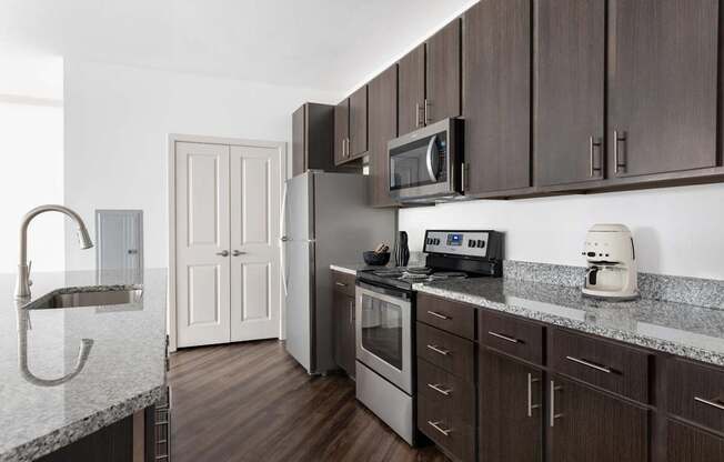 A kitchen with brown cabinets and a white counter.