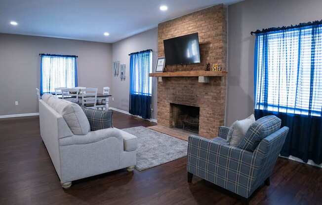 A living room with a fireplace and two chairs.