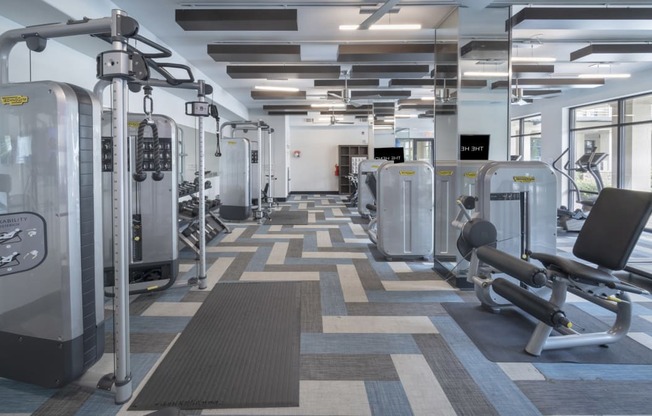 a large fitness room with cardio machines and weights at The Hendrix, Georgia, 30329