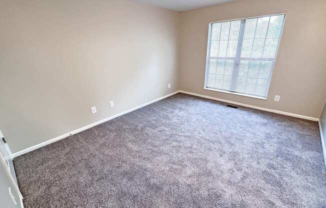 an empty room with carpet and a window