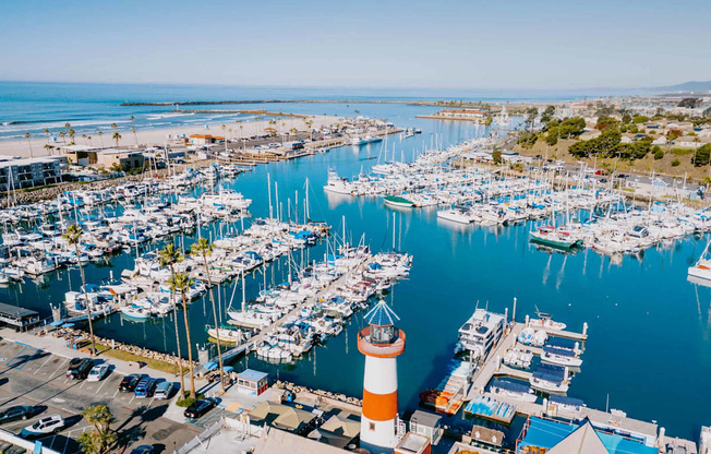 a view of the marina with many boats and a lighthouse