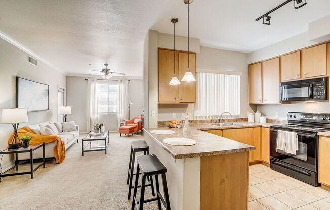 an open kitchen and living room with a large counter top at Adiamo Palm Valley, Goodyear, Arizona