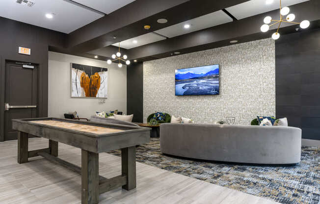 A modern living room with a wooden table and a grey sofa.