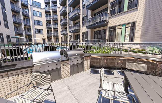 a patio with a grill and chairs and an apartment building