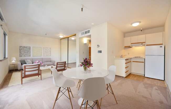 a living room with a table and chairs and a kitchen