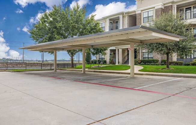 a covered parking lot in front of an apartment building