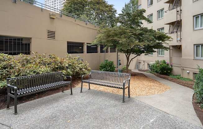 two park benches in front of an apartment building