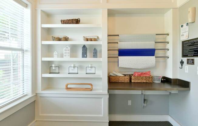 A kitchen pantry with white shelves and a blue and white striped towel hanging on the wall.