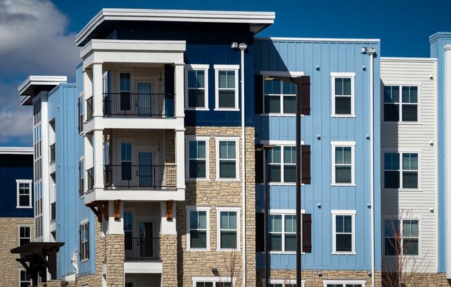 an image of an apartment building with brick and blue exterior