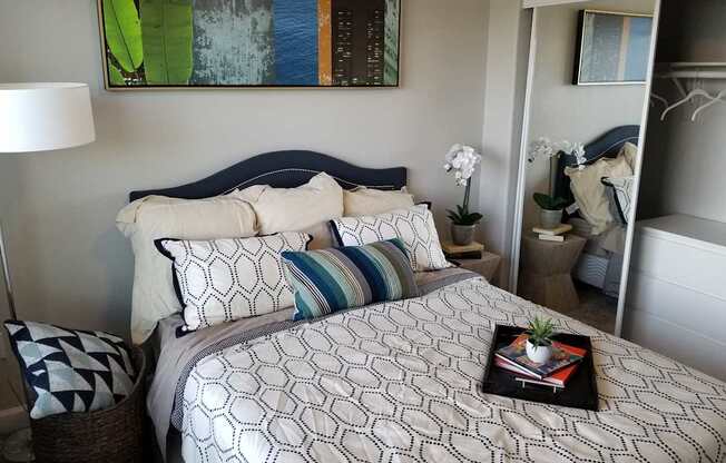 a bedroom with a bed and a nightstand with a plant on it