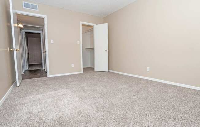 A bedroom with a carpeted floor and beige walls  at The Creole Apartments in Shreveport, LA