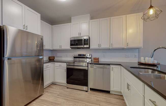 a kitchen with white cabinets and stainless steel appliances