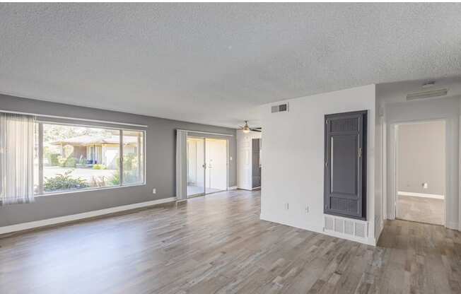 a living room with hardwood floors and grey walls