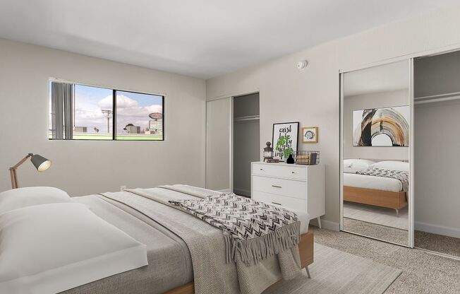 A bedroom with a large bed and a dresser with a mirror.