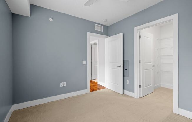 a bedroom with blue walls and white doors and a carpeted floor