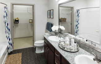 A bathroom with a toilet, sink, and mirror.