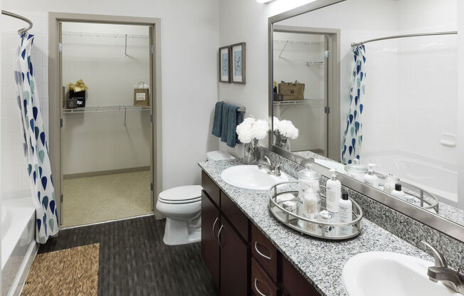A bathroom with a toilet, sink, and mirror.