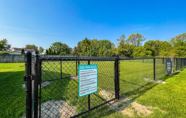 a dog park with a black chain link fence and a sign that says dog park closed  at Park On Canal Apartments, Clinton Twp, MI